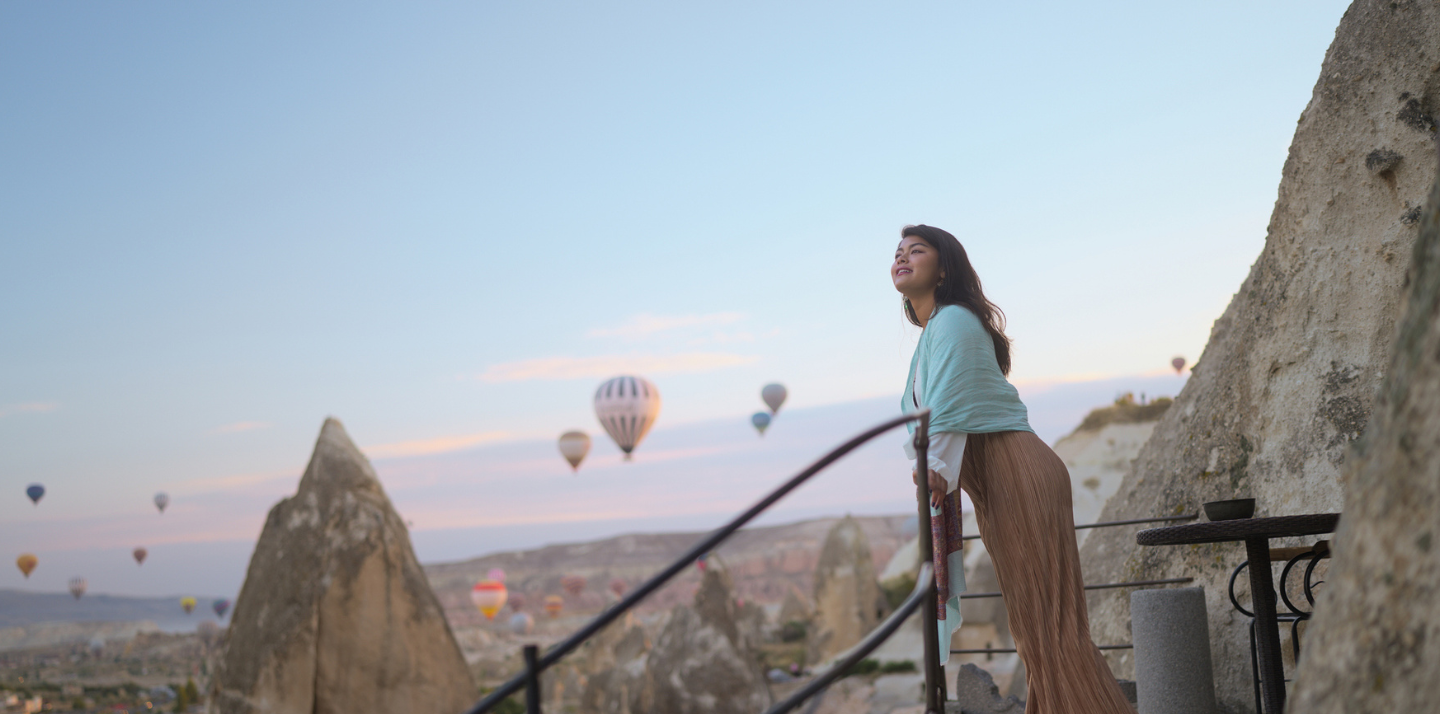 Woman watching hot air balloons during solo travel in Cappadocia.
