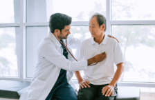 Doctor checking patient's heart at a travel health care appointment