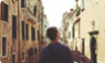 person walking between buildings